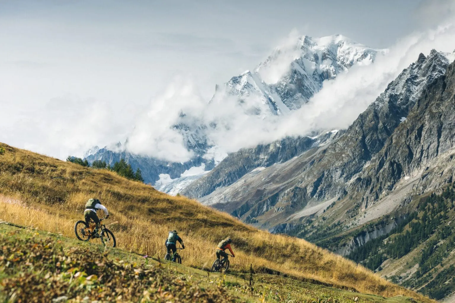 Un gruppo in mountain bike sopra la Val Ferret, davanti al massiccio del Monte Bianco